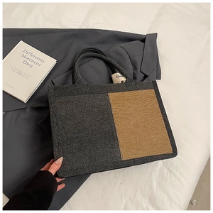 Detail of minimalist felt tote bag showing contrasting color panels and side stitching