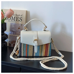 Détail d'un sac bandoulière tissé avec motif à vagues colorées et bandoulière corde