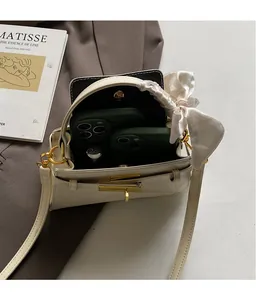 Détail du sac à main blanc motif crocodile montrant l'intérieur et le fermoir doré