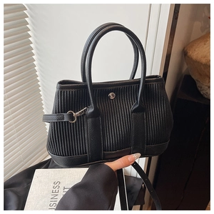 Detail of black pleated bucket bag featuring textured leather and silver hardware