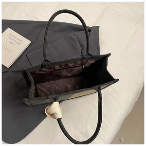 Detail view of large grey canvas tote bag interior with monogram lining and silk ribbon