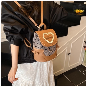 Detail of mini backpack with brown leather patchwork and black and white bow print