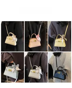 Détail de mini sacs carrés tendance en plusieurs couleurs avec motif croco et foulard en soie