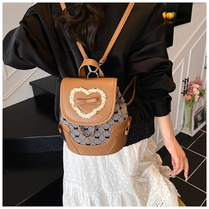 Detail view of brown PU leather backpack with bow accent and chain on model back