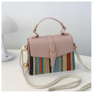 Détail d'un sac bandoulière tissé avec rabat en cuir rose et bandoulière en corde blanche