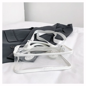 Detail der transparenten PVC-Gelee-Tasche mit weißer Paspel und breitem Schultergurt