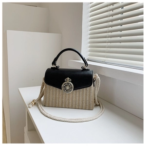 Detail of straw patchwork bag with golden metal lock and white rope shoulder strap