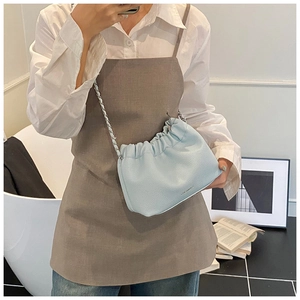 Detail of light blue pleated cloud bag with litchi texture and silver chain strap