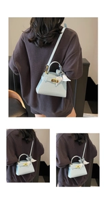 Détail du sac bandoulière bleu clair à motif crocodile avec foulard décoratif sur la poignée