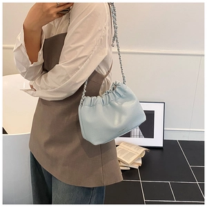 Detail of light blue ruched cloud bag with silver chain strap and lychee grain texture