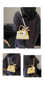 Détail du sac à main jaune crème motif crocodile avec fermoir doré et foulard imprimé