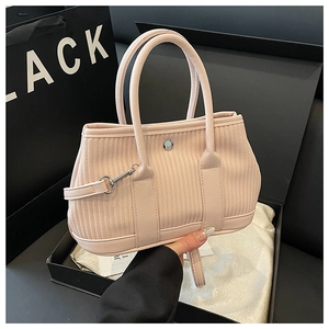 Detailed view of the textured pink bucket bag with silver hardware and dual handles