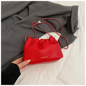 Macro shot of red pleated cloud bag with litchi grain texture and metal chain strap