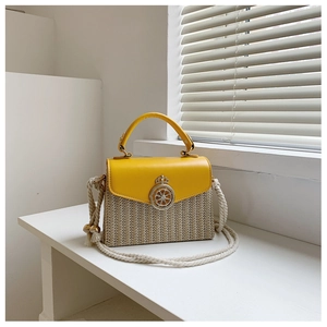 Detail of yellow leather flap and straw woven texture with golden clasp and rope strap