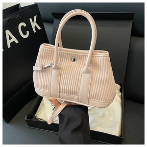 Detail of light pink bucket bag with vertical pleats and silver metallic hardware snap