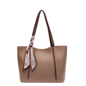 Minimalist taupe tote bag with lychee texture and floral silk scarf accessory on white base