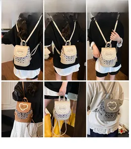 Detail view of mini bow backpack in beige, brown, and grey with lace heart design