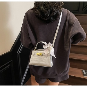 Mini sac argenté à motif crocodile avec fermoir doré et foulard en soie sur la poignée