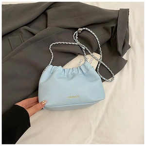 Detail of light blue lychee pattern leather crossbody cloud bag with silver chain strap