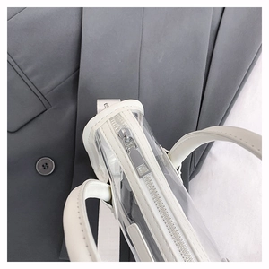 Detail der transparenten PVC-Tasche mit weißem Lederbesatz und silbernem Reißverschluss