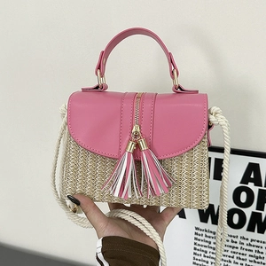 Detail view of pink leather flap and woven straw textures with gold tassel zipper