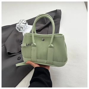 Detail of mint green pleated tote bag with silver buckle and vertical texture
