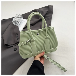 Detail of mint green pleated bucket bag with vertical texture and silver metal buckle