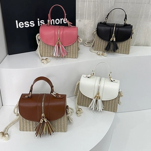Detail showing four straw handbags with colored leather flaps and stylish tassels