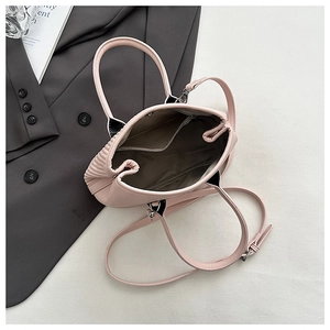 Detail view of pink textured bucket bag interior with zipper pocket and lining