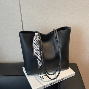 Black matte leather tote bag with geometric scarf handle, modern commuter shoulder bag
