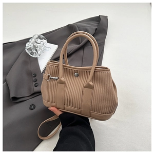Detail of khaki corduroy bucket bag texture with top handles and silver lock clasp