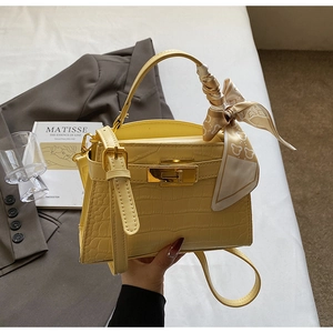 Sac à main jaune motif crocodile avec fermoir doré et détail de foulard en soie élégant