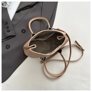 Close-up of khaki pleated handbag interior showing dark brown lining and inner zipper pocket