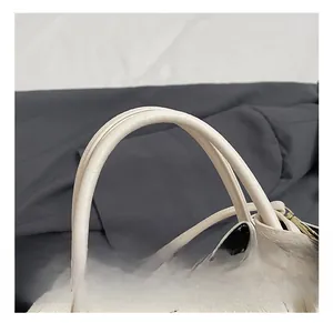 Detail of off-white lychee grain leather handbag with dual handles and fine stitching
