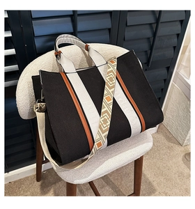 Détail du cabas en toile avec garniture en cuir marron et bandoulière tissée