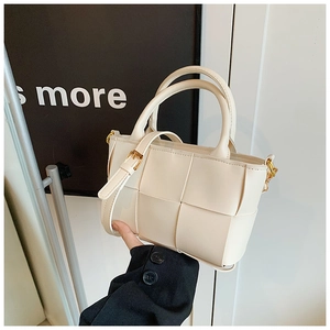 Detail showing the cream-colored PU leather woven texture and adjustable strap of the tote bag