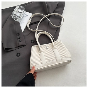 Top view of cream pleated bucket bag with long strap on a grey blazer outfit