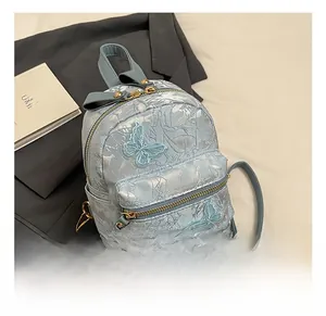 Close-up of light blue jacquard floral backpack featuring 3D butterfly embroidery detail