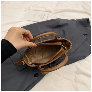 Top view of brown leather handbag interior showing zipper closure and inner pocket