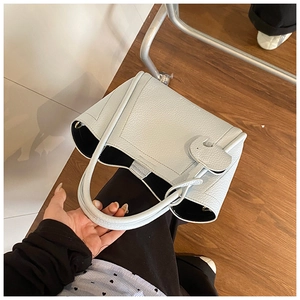 Detail of light blue pebble leather bucket bag with cute elephant charm and black lining