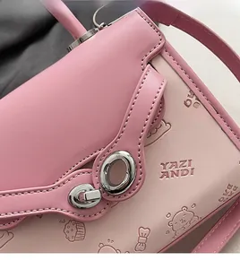 Detailed view of pink leather bag featuring 3D cartoon embossing and a silver metal lock