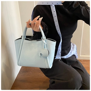 Detail of light blue lychee pattern tote bag featuring a cute elephant charm accessory