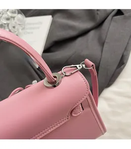 Detail of silver round metal ring and detachable shoulder strap on pink leather handbag
