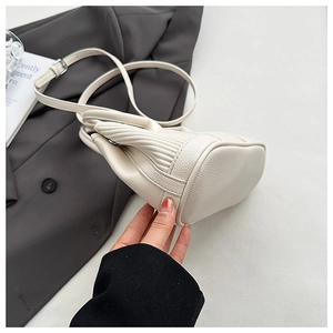 Close-up of off-white lychee texture leather bucket bag base and adjustable strap