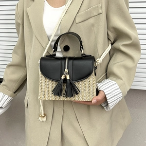Fashionable straw handbag with black leather trim and white cotton rope shoulder strap