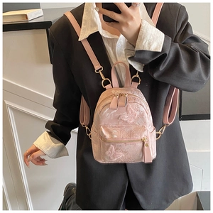 Détail du mini sac à dos rose avec broderie papillon montrant la texture jacquard florale