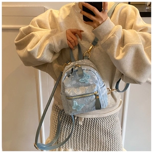 Détail du mini sac à dos bleu avec broderie papillon 3D et fermetures éclair dorées