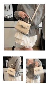 Detail of cream white handbag with embossed teddy bear pattern and detachable strap