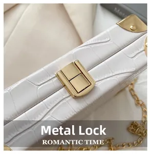 Detail of gold push-lock closure on white croc-effect leather box bag with chain