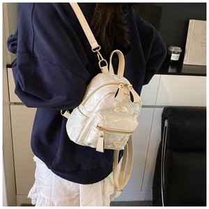 Gros plan d'un mini sac à dos blanc avec broderie florale et papillon délicate